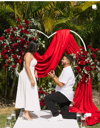 Propuesta de matrimonio frente a una decoración roja